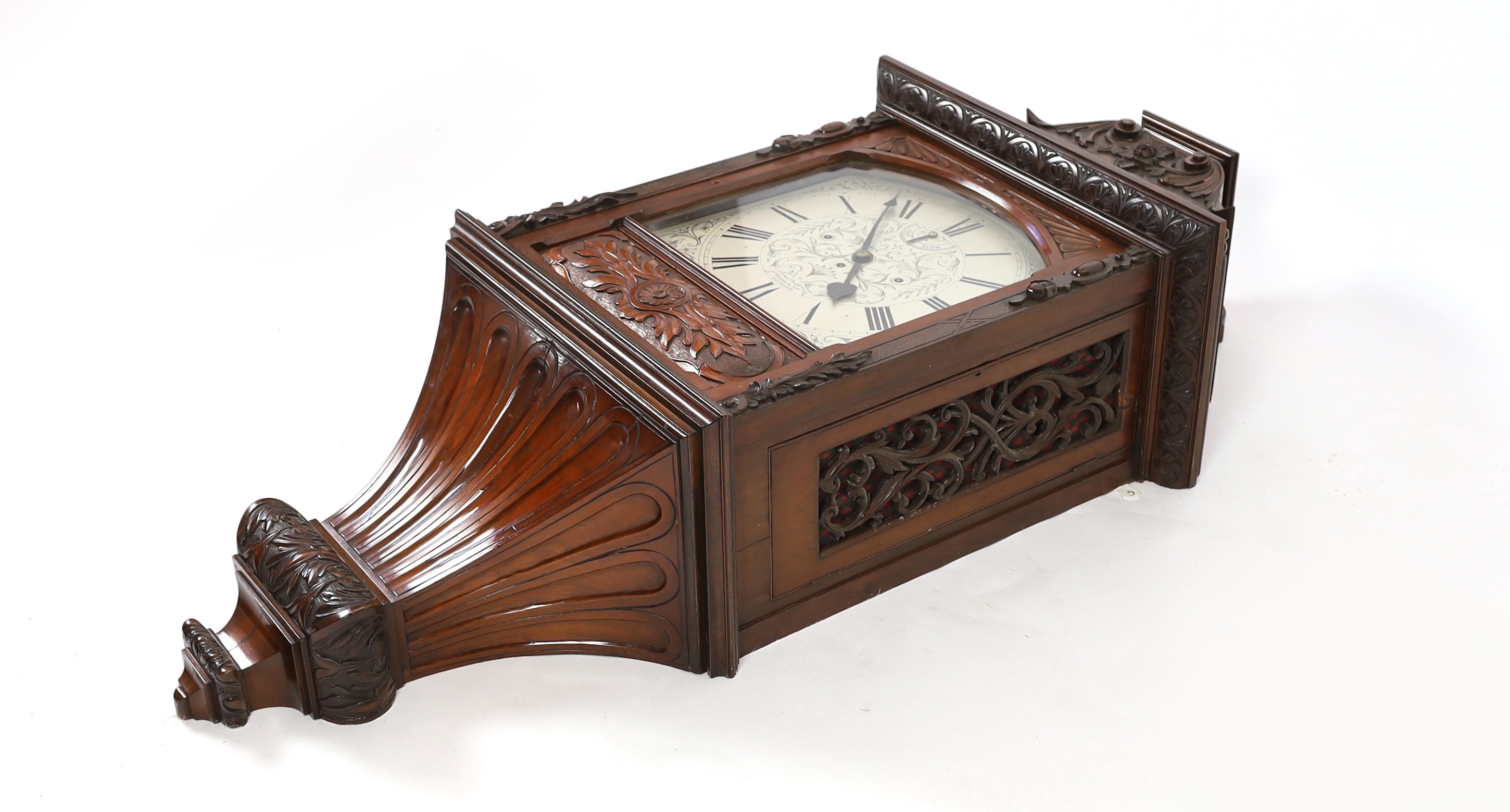 A large and impressive early 20th century carved mahogany cased wall clock, the triple fusee movement striking on a cluster of eight bells and five gongs, the 39cm engraved arched silvered dial with fast / slow select ma